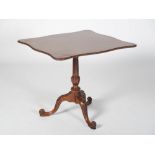 A George III mahogany snap top tea table, the shaped rectangular top with a foliate carved edge,