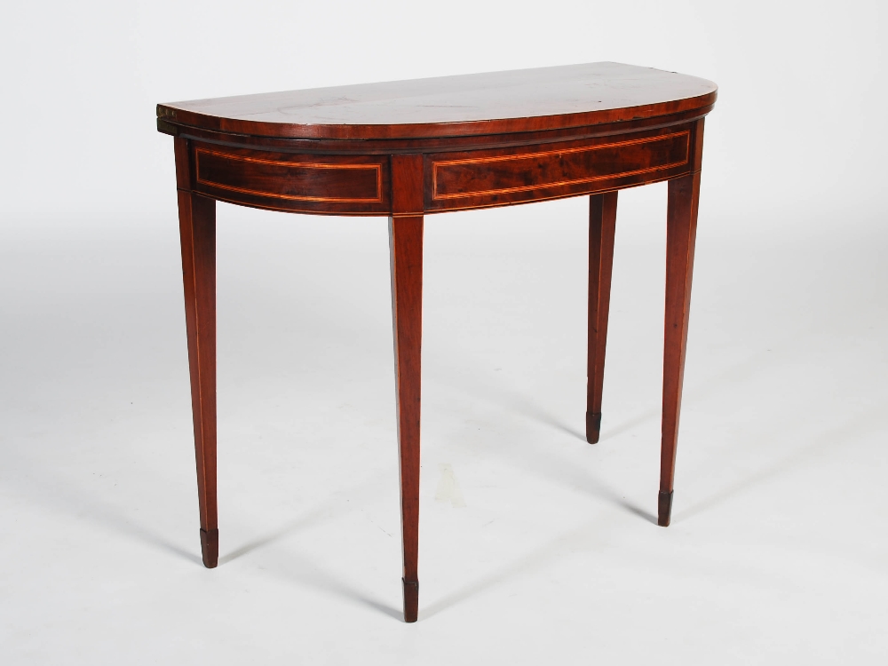 A George III mahogany and satinwood banded demi lune card table, the hinged top opening to a baize