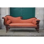 A 19th century mahogany chaise lounge, with upholstered back, arms and seat and two loose bolster