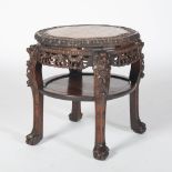 A Chinese dark wood jardiniere stand, Qing Dynasty, the shaped circular top with a mottled red and