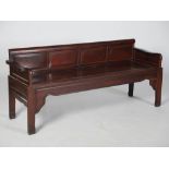 A Chinese dark wood bench, Qing Dynasty, the four panelled back above a panelled seat, raised on