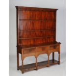 A George III oak dresser, the upright back with three open shelves and later painted back panel,