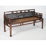 A Chinese dark wood sofa, the pierced back and sides carved with dragons, lotus and scrolls, above a