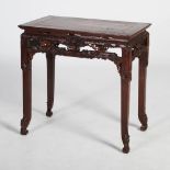 A Chinese dark wood table, Qing Dynasty, the panelled rectangular top above a pierced and carved