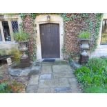 Pair of tall iron urns on plinths