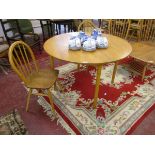 Light elm Ercol circular dining table with 2 Ercol dining chairs