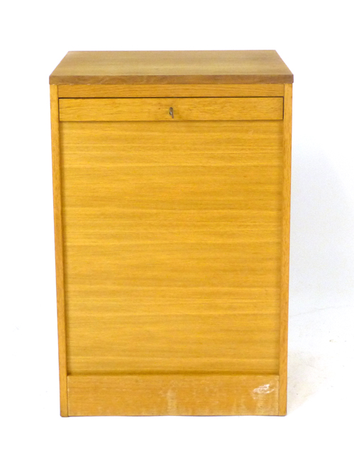 A 1970's oak tambour door cabinet, the interior with fitted shelves, on a plinth, h.