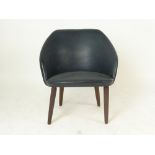 A 1970's vinyl tub chair on teak tapering legs CONDITION REPORT: Wear commensurate