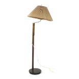 A 1970's turned beech standard lamp with a stainless steel bent and adjustable shaft on a circular