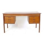 A 1970's teak desk with an arrangement of six drawers on square straight legs, l.