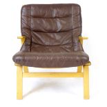A Danish oak framed armchair with loose brown leather cushions,
