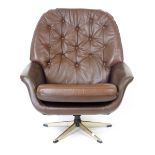 A 1970's brown vinyl and button upholstered swivel armchair on a chromed five star base