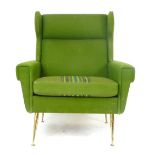 A 1950's green wingback armchair on metal tapering feet CONDITION REPORT: Would