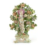 A 19th century figural flatback in the form of a dandy flanked by foliate decoration on a