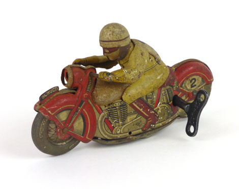 A Schuco sport tinplate clockwork motorcycle with rider, base colour of the motorcycle being red,