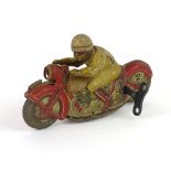 A Schuco sport tinplate clockwork motorcycle with rider, base colour of the motorcycle being red,