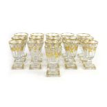 A set of sixteen 19th century gilt decorated liqueur glasses, with square bases,