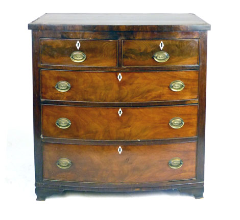 An early 19th century mahogany bow fronted chest of two over three graduated drawers on ogee