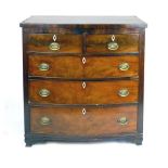 An early 19th century mahogany bow fronted chest of two over three graduated drawers on ogee