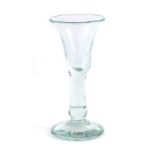 An 18th century drinking glass, the bell form bowl over a plain stem and knob, h.