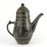 A Nigerian coffee pot by Abuja Pottery, the grey ground incised with swirling motifs, h.