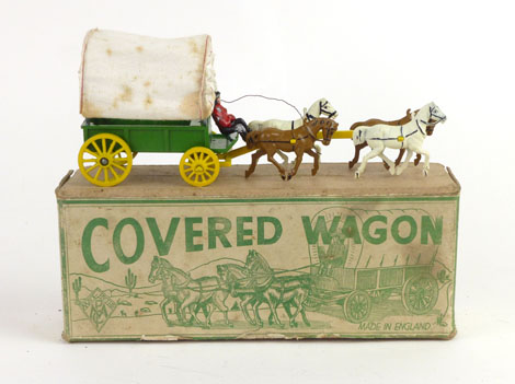 A Wild West-style covered wagon cast metal toy, the green wagon with yellow wheels,