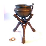 A 19th century Indian brass bowl on a wooden stand,