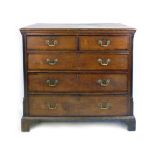 A George III oak and mahogany crossbanded chest of two over three graduated drawers flanked by