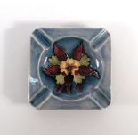 A Moorcroft 'Hibiscus' pattern ashtray of square form, plain impressed base, w.