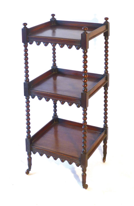 A Regency mahogany three tier whatnot, with bobbin turned supports and arched aprons to each shelf,