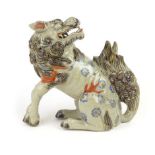 An early 20th century Chinese figure modelled as a foo dog with its head facing backwards, h.