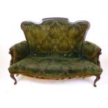 An early 20th century mahogany two seat settee upholstered in very distressed green cut fabric,