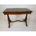 A Victorian burr walnut card table, the fold over serpentine shaped top on reeded end supports