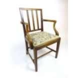 A Georgian mahogany open arm chair with needle work upholstered drop in seat, h. 92 cm, w. 58 cm, d.