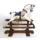 A late Victorian white painted child's rocking horse on a painted wooded plinth,