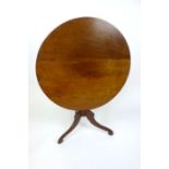 An 18th century and later mahogany tilt-top tripod table, on turned column and three S-scroll legs,