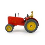 A Dinky Toys Massey Harris tractor 27A with driver painted red body and yellow hubs