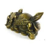 A Chinese brass paperweight modeled as three graduated turtles on a pile of coins,