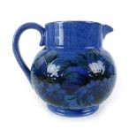 A William Moorcroft jug, decorated in the 'Cornflower' pattern on a blue ground,