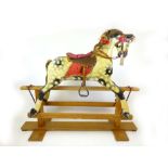 A late Victorian painted child's rocking horse on a painted wooded plinth,