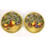 A pair of cabinet plates depicting still life fruit scenes, both signed by Royal Worcester artist D.