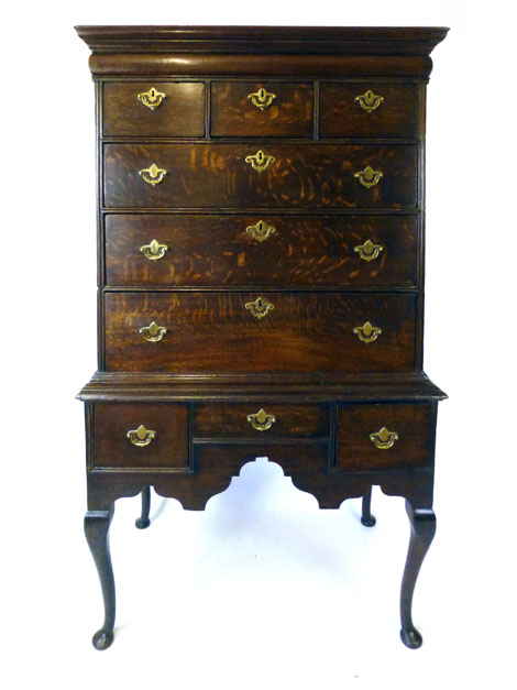 An early 18th century oak chest on stand with cushion drawer above three short over three long on a