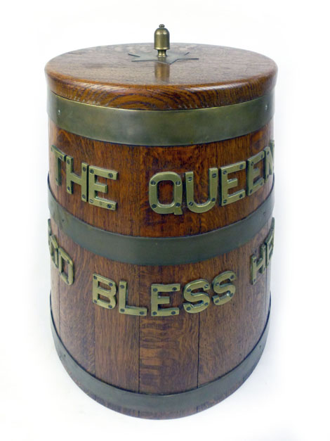 A ship's oak rum barrel of tapering form with applied brass inscription 'The Queen God Bless Her'