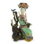 A 20th century studio pottery luster-style figure of a geisha sat on a tree with birds,