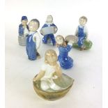 A group of Royal Copenhagen ceramic figures modeled as children to include boy on marrow No.