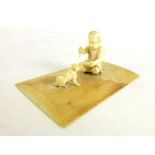 A (?) POW ivory carved model in the form of a young child and dog on a base, l. 9 cm, w.