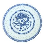 A 19th century Chinese blue and white dish with a rice edged border, with central dragon, d.