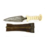 An 18th century African double edged dagger in a leather and metal scabbard, with an ivory handle,