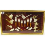 A presentation case of 19th century clay pipes and 20th century cigarette holders,