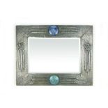 An Arts & Crafts mirror with an embossed white metal frame with Ruskin style plaques and beveled